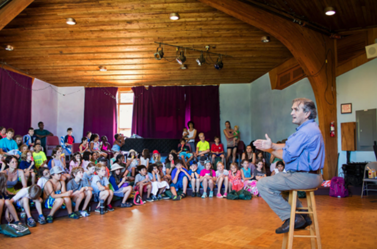 Dr. Stead speaking to a circle of children, telling stories
